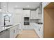 Stylish kitchen with white cabinets, stainless appliances, and modern fixtures at 1783 Juniper Berry Way, Loganville, GA 30052