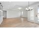 Open-concept living room with hardwood floors, tray ceiling and modern chandelier at 1783 Juniper Berry Way, Loganville, GA 30052