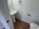 Stylish powder room featuring a pedestal sink, modern fixtures, and hardwood floors at 3210 Linden Dr, Lawrenceville, GA 30044