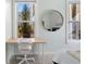 Bright bedroom with a desk, round mirror, and window view of neighborhood greenery at 870 Inman Village Ne Pkwy # 229, Atlanta, GA 30307