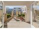 Patio featuring 2 wood chairs, brick pillars, and view of apartment buildings through gate at 870 Inman Village Ne Pkwy # 229, Atlanta, GA 30307