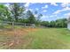 Backyard featuring a well-maintained lawn, privacy fence, and mature trees at 99 Oxford Ln, Kingston, GA 30145