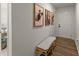 Hallway featuring wood-look floors and framed pictures leading to a bright doorway at 99 Oxford Ln, Kingston, GA 30145