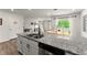Well-lit kitchen showcasing granite counters, a stainless dishwasher, and a view to the living room at 99 Oxford Ln, Kingston, GA 30145