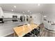 Open-concept kitchen with granite counters, white cabinets, and a wooden dining table nearby at 99 Oxford Ln, Kingston, GA 30145