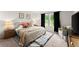 Comfortable main bedroom features a king-size bed, warm lighting, and view of the backyard at 99 Oxford Ln, Kingston, GA 30145