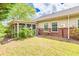 Backyard featuring grass, partial brick wall, partial screened porch and some greenery at 2318 Chancery Mill Ln, Buford, GA 30519