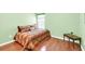 A bedroom featuring green walls, wood floors, a patterned comforter, and a window with blinds at 2318 Chancery Mill Ln, Buford, GA 30519