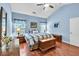 A bedroom with blue walls, a vaulted ceiling, wood floors, large windows, a ceiling fan, and a bed at 2318 Chancery Mill Ln, Buford, GA 30519