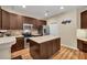 A kitchen featuring dark cabinets, stainless steel appliances, an island with countertops, and neutral tile backsplash at 2318 Chancery Mill Ln, Buford, GA 30519