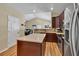 A kitchen featuring dark cabinets, stainless steel appliances, an island with countertops, and neutral tile backsplash at 2318 Chancery Mill Ln, Buford, GA 30519