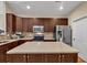 A kitchen featuring dark cabinets, stainless steel appliances, an island with countertops, and neutral tile backsplash at 2318 Chancery Mill Ln, Buford, GA 30519