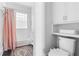 Bathroom with shower/tub combination, glass block window and adjacent toilet and shelving at 291 Elmira Ne Pl, Atlanta, GA 30307