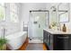 Bright bathroom featuring a soaker tub, glass shower and vanity with & sinks at 291 Elmira Ne Pl, Atlanta, GA 30307