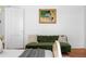 Cozy green velvet couch next to a bed and hanging art at 291 Elmira Ne Pl, Atlanta, GA 30307
