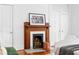 Wooden fireplace with artwork above and a white bed adjacent at 291 Elmira Ne Pl, Atlanta, GA 30307