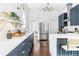 Bright kitchen features stainless steel refrigerator, quartz counters, and blue cabinets at 291 Elmira Ne Pl, Atlanta, GA 30307