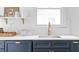 Kitchen sink featuring modern faucet, bright countertop, and navy cabinets offering a clean and functional design at 291 Elmira Ne Pl, Atlanta, GA 30307