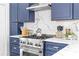 Updated kitchen with stainless steel stove, quartz counters, and blue cabinets at 291 Elmira Ne Pl, Atlanta, GA 30307