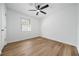 Bright bedroom featuring new hardwood flooring, ceiling fan, and neutral white walls at 5570 Deerfield Nw Pl, Kennesaw, GA 30144