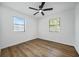 Bright bedroom featuring hardwood flooring, a ceiling fan, and two windows at 5570 Deerfield Nw Pl, Kennesaw, GA 30144