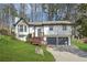 Charming home featuring two-car garage, wood deck and inviting curb appeal with mature trees at 5570 Deerfield Nw Pl, Kennesaw, GA 30144