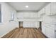 Eat-in kitchen features white cabinets and wood-look floors at 5570 Deerfield Nw Pl, Kennesaw, GA 30144