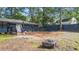 A spacious backyard with a wooden fence, fire pit, and lush greenery at 715 Wood Valley Rd, Mableton, GA 30126