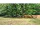 View of the backyard with a wood fence and mature trees at 715 Wood Valley Rd, Mableton, GA 30126