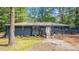 The backyard featuring a wooden deck, firepit, and lush green lawn at 715 Wood Valley Rd, Mableton, GA 30126