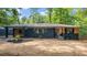 Charming one-story home featuring a brick facade, wood accents, a covered carport, and manicured landscaping at 715 Wood Valley Rd, Mableton, GA 30126