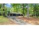 Full exterior view showing the home's architectural style, mature trees, driveway, and surrounding landscape at 715 Wood Valley Rd, Mableton, GA 30126