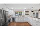 Bright kitchen features white cabinetry, stainless steel appliances, and hardwood floors at 715 Wood Valley Rd, Mableton, GA 30126