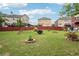 Large, grassy backyard with landscaped flowerbeds and a red fence surrounding the perimeter at 2120 Cain Commons Dr, Dacula, GA 30019