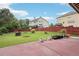 Open backyard featuring green grass, small flowerbeds, and a red fence around the property at 2120 Cain Commons Dr, Dacula, GA 30019
