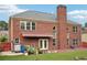 Exterior of brick house with large chimney overlooking the green backyard and red fence at 2120 Cain Commons Dr, Dacula, GA 30019