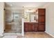 Modern bathroom featuring a glass-enclosed shower, tile floors, and custom cabinets at 2120 Cain Commons Dr, Dacula, GA 30019