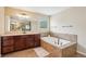 Bright bathroom features a tiled tub, dual vanities, and an expansive mirror at 2120 Cain Commons Dr, Dacula, GA 30019