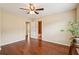 Bedroom with hardwood flooring features neutral walls, fan and access to bath at 2120 Cain Commons Dr, Dacula, GA 30019