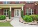 Walkway to the front door of a brick home with manicured landscaping at 2120 Cain Commons Dr, Dacula, GA 30019