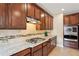 Modern kitchen featuring granite counters, stainless appliances, and dark wood cabinets for culinary excellence at 2120 Cain Commons Dr, Dacula, GA 30019