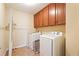 Well-lit laundry room with washer, dryer, storage cabinets and tile flooring at 2120 Cain Commons Dr, Dacula, GA 30019
