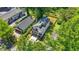 Aerial view of a modern home with a rooftop terrace and a fenced backyard surrounded by green trees at 2186 Park Terrace, College Park, GA 30337