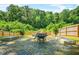 Backyard firepit area with stone benches surrounded by a privacy fence and lush trees at 2186 Park Terrace, College Park, GA 30337