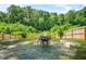 Backyard firepit area with stone benches surrounded by a privacy fence and lush trees at 2186 Park Terrace, College Park, GA 30337