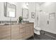 Modern bathroom featuring double vanity, stylish mirrors, glass shower, and patterned tile floor at 2186 Park Terrace, College Park, GA 30337