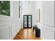 Bright hallway featuring paneled walls, hardwood floors, and a dark double-door entry at 2186 Park Terrace, College Park, GA 30337