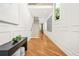 Bright hallway with hardwood floors, wainscotting, and decorative bench with view of wooden stairs at 2186 Park Terrace, College Park, GA 30337