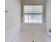 White bathtub with window and white tile accents at 2429 Wood Bend Ln, Riverdale, GA 30296