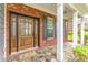 Inviting front porch with a beautiful wood door, stone walkway, and classic white columns at 3016 Levinshire Way, Dacula, GA 30019